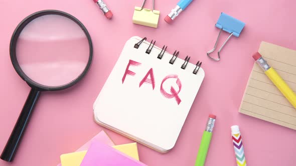 Hand Drawing Text FAQ on Notepad on Pink Background alt