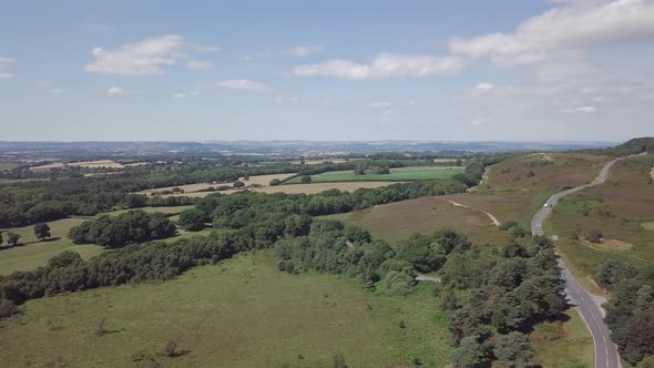 Aerial view of agricultural land in Woodbury England. Overhead view of cars driving on road through alt