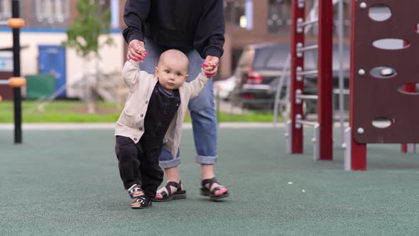 Baby Boy Holding Hands His Mom and Walking Together at the Playground