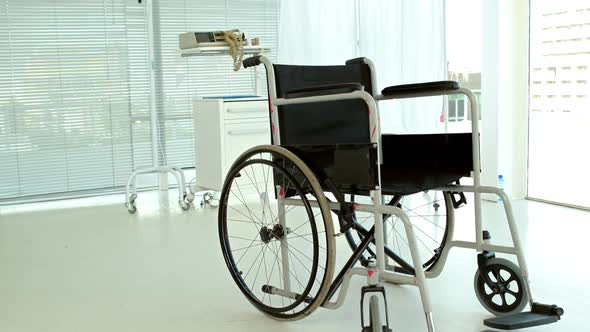 Black wheelchair in medical bedroom alt