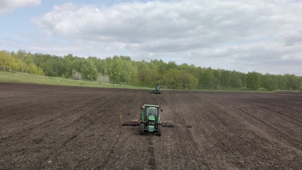 Agricultural tractor in the field fluff the earth. alt