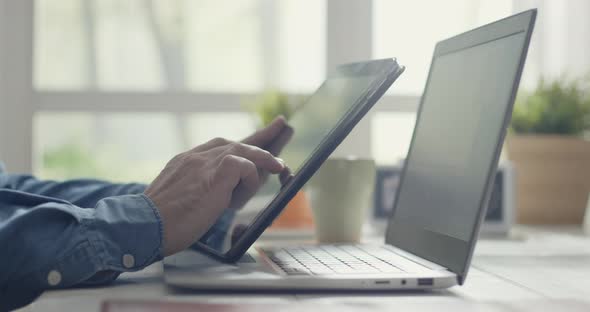 Man sitting at desk and using a digital tablet