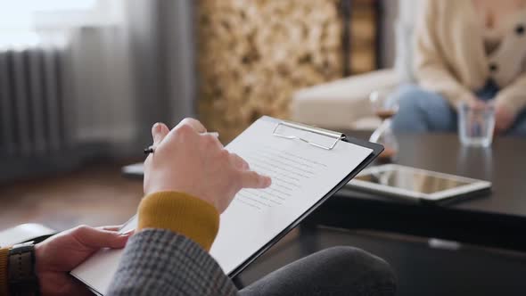 Man which Sitting in the Chair, Holding Folder with Main Notes for Him alt
