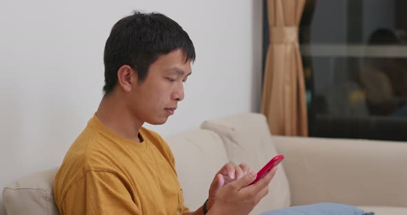 Man use of cellphone at home alt