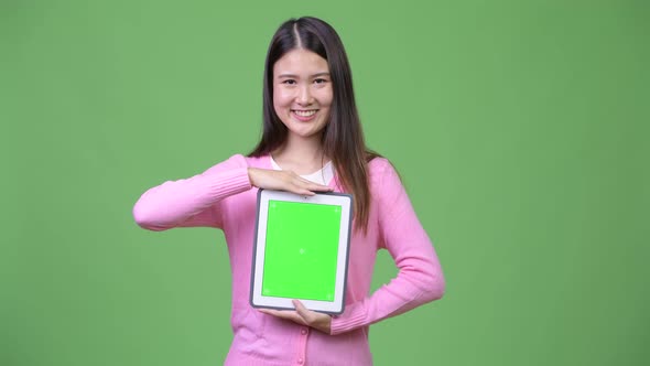 Young Beautiful Asian Woman Showing Digital Tablet