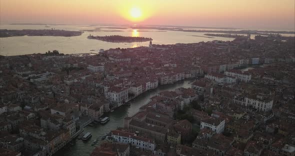 Aerial shot flying towards sunrise and Cannaregio area over Canal Grande , Venice, Italy alt