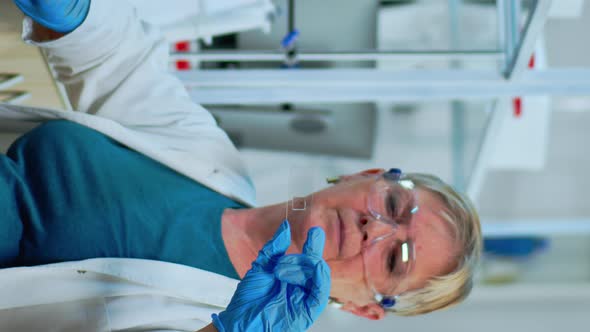 Vertical Video Senior Woman Lab Technician Looking at Virus Sample alt