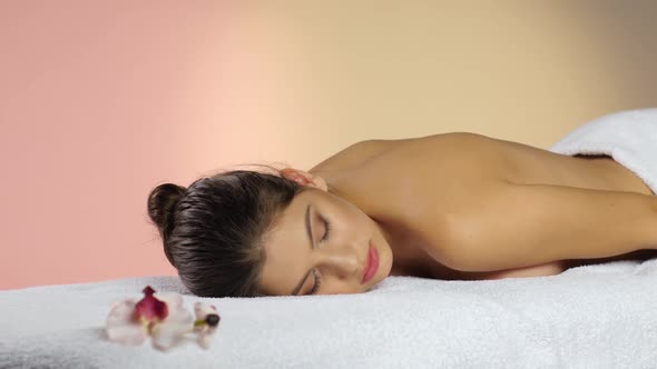 Girl Sleeps on the White Towels. Rest After Spa Treatments alt