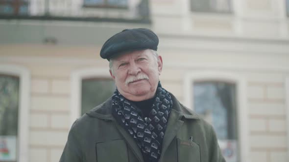 Happy White-haired Man in a Flat Cap Smiling at a Nice House in Slo-mo    alt