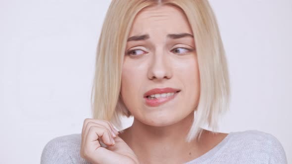 Young Beautiful Shy Blonde Girl Smiling Over White Background alt