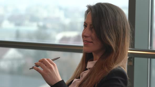 Businesswoman holding a pen alt