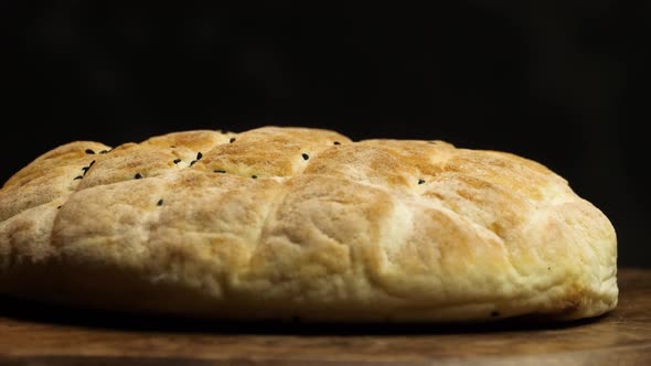 Tasty Mediterranean flatbread turns against a black background