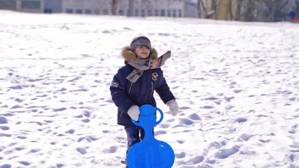 child boy having fun, playing and laughing on snowy winter walk in nature. alt