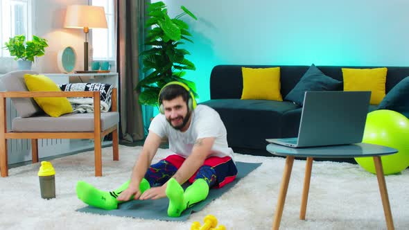 There s a Man Sitting on a Workout Mat He is Doing alt