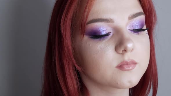 Closeup View of Beautiful Young Girl Model with Bright Red Hair and Purple Makeup Posing in the alt