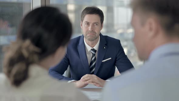 Rear Back View of Couple Having Conversation with Middle Aged Agent alt