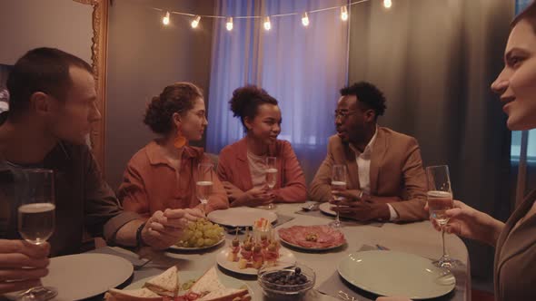 People Toasting with Champagne Glasses at Dinner Party alt