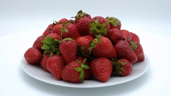 Strawberries on a plate rotating on a white background. Strawberry ripe season alt