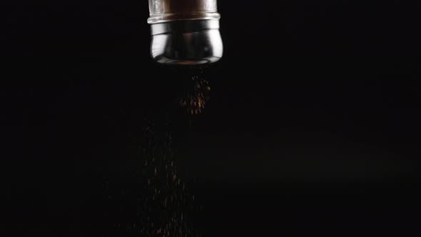 Red Pepper Falling Out From Pepperpot on Black Background in Slomo alt