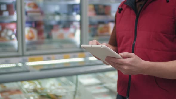 Unrecognizable Merchandizer With Tablet alt