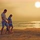 Happy Family Walks Along the Seashore at Sunset Parents Hold Their Son&#39;s Hands - VideoHive Item for Sale