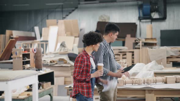 People Walking in Workshop Talking Discussing Work Holding Coffee and Tablet alt