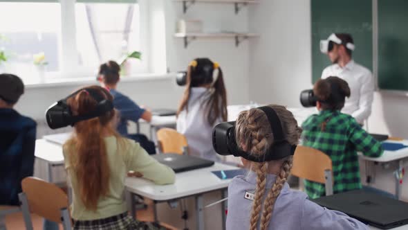 Teacher Teaches an Interactive Lesson at Modern School Childs in Virtual Reality Glasses Learning in alt