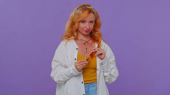 Sincere Cool Cheerful Stylish Girl in White Shirt Wearing Sunglasses Charming Smile on Purple Wall alt