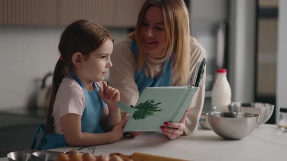 Happy Mother and Daughter is Learning to Cook in Home Kitchen Mom and Child are Spending Weekend alt