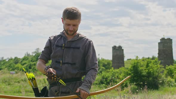 a Young Guy Shoots a Bow at a Target in Nature and Hits the Target the Arrow Pierces the Target for alt
