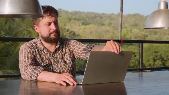 Handsome Bearded Man  Opening Laptop and Starting Work Outdoor