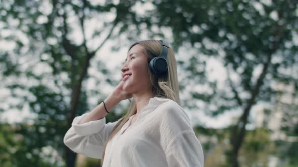 Asian woman enjoying the breeze outdoors.