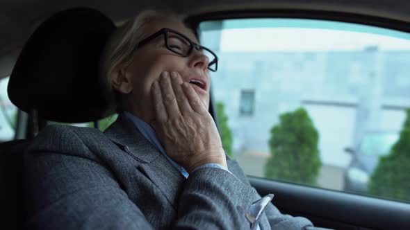 Mature Woman Feeling Toothpain Sitting in Car, Gum Sensitivity Caries Prevention