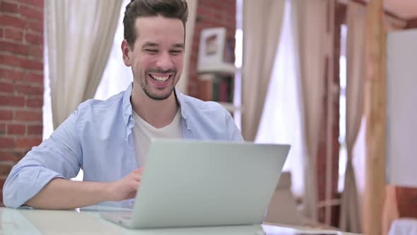 Young Man Doing Video Chat on Laptop alt