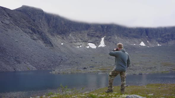 A Man Drinking Hot Coffee on the Bank of a Clean Mountain Stream in the Khibiny