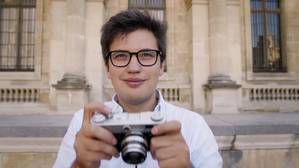 Handsome Man in White Shirt Taking a Picture of Paris Architecture