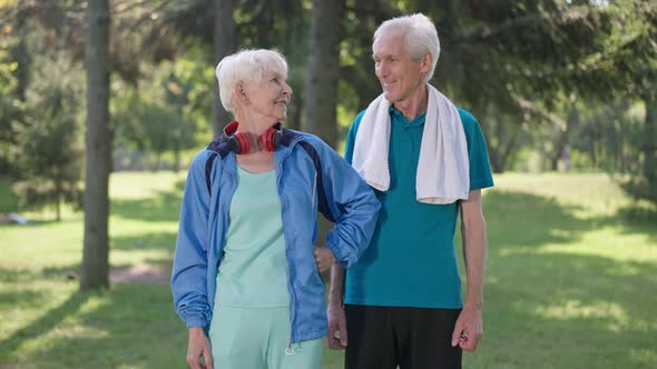 Proud Senior Couple of Retirees Looking at Camera Gesturing Strength in Slow Motion Smiling alt