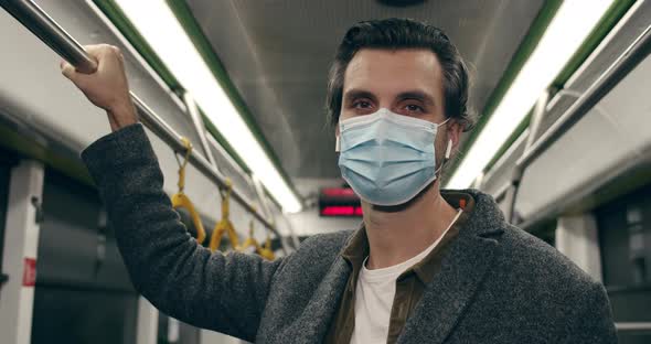Close Up of Handsome Male Person in Protective Medical Mask Turning Head and Looking To Camera alt