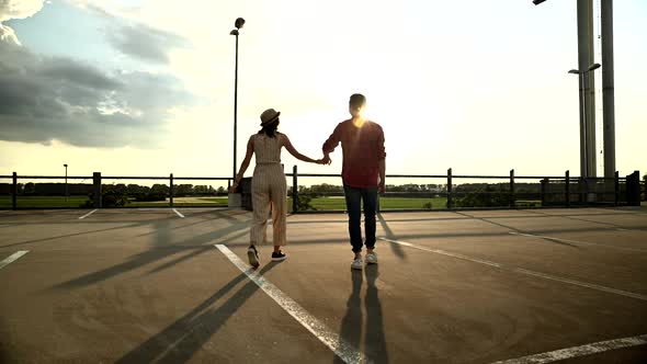 Young couple walking on parking deck alt