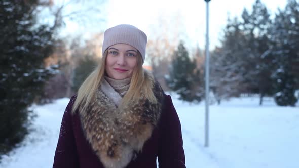 A Beautiful Girl Walks Through the Winter Park with a Good Nod alt