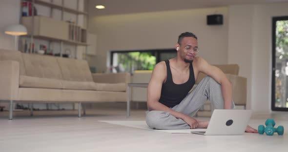 African American Fitness Trainer Using Laptop for Online Training with Client During Coronavirus alt
