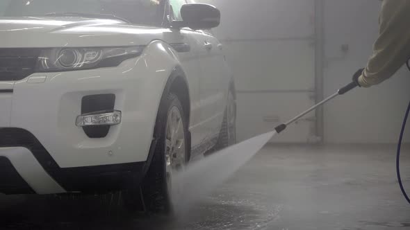Car Washing at Selfservice Station Hose for Spraying Water in a Garage