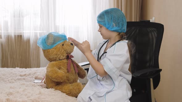 Patient playing hospital game pretend nurse. Child puts on a medical cap and mask alt