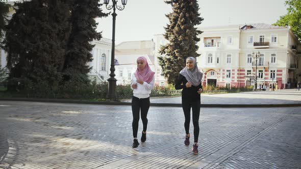 Two Muslim Females in Sport Clothes and Colorful Hijabs alt