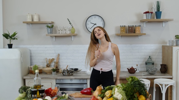 Happy Vegan Girl with Slim Waist Dancing, Singing in Kitchen. Raw Vegetable Nutrition Diet Concept alt
