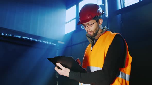 The Ingineer Works in a Warehouse Uses a Tablet alt