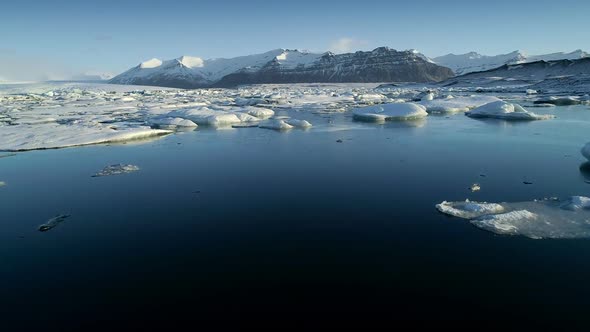 Flying Above Floating Icebergs. Ice From Glacier Crystal Shining. Ice Lagoon Global Warming alt
