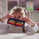 Curious Girl Turns and Looks at Abacus Sitting at Table - VideoHive Item for Sale