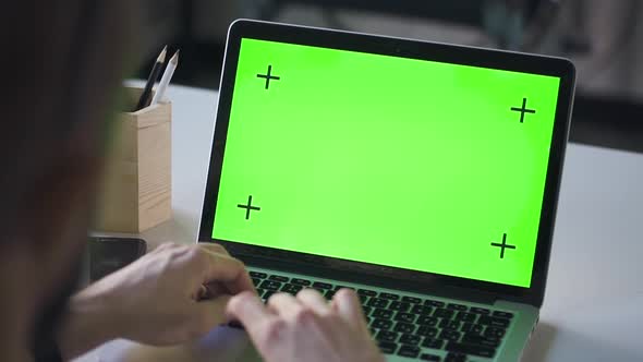 Man Student Working on Laptop Computer with Green Screen at Library Table alt