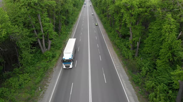 Road with Cars. Logistics Transportation and Delivery of Goods. The Highway Between the Trees..